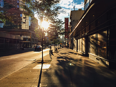 vehicles parked beside the road near people during golden hour thumbnail
