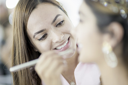 smiling woman brushing womans lips thumbnail