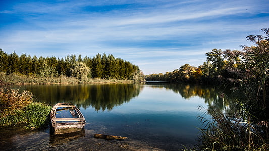 gray rowing boat on body of water during daytime thumbnail