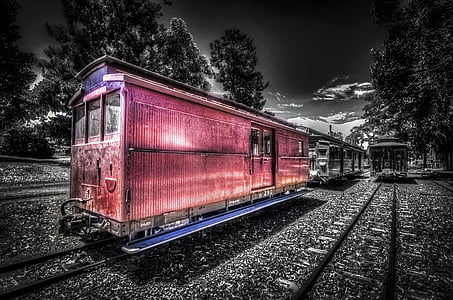 selective color photography of train under cloudy sky thumbnail