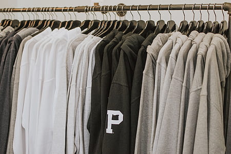 gray, black, and white hoodies hanged on rack thumbnail