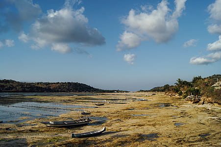 several boats near lake under cloudy sky thumbnail