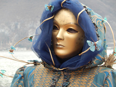 person wearing gold mask and blue headdress thumbnail