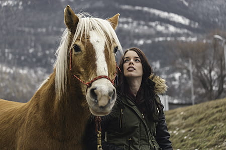 woman standing beside horse with background of mountain range thumbnail