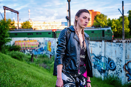 woman wearing black leather jacket and black and white button during daytime thumbnail
