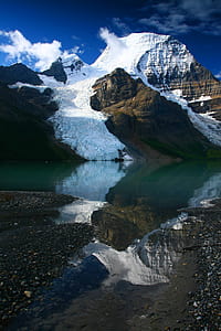 brown mountain covered with snow near body of water thumbnail