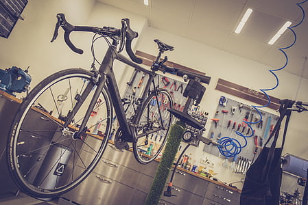 black road bike beside green stand thumbnail