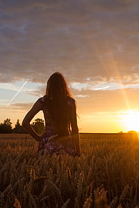 standing woman on grass at sunset thumbnail