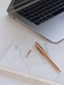 gold click pen on white Journal book thumbnail
