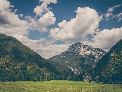 green grass field surrounded by mountains thumbnail