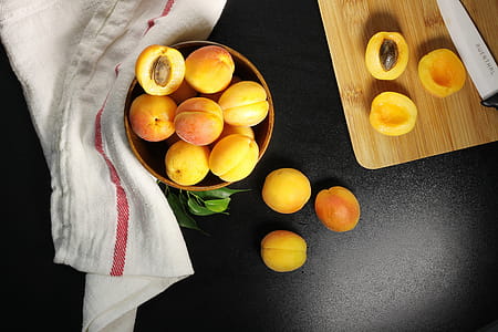 Overhead Shot Of Fresh Apricots Being Halved And Pitted Photo thumbnail
