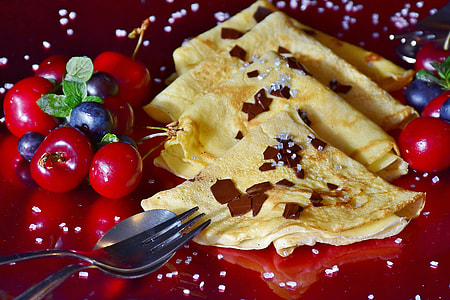 closeup photo of quesadilla beside red cherries and stainless steel spoon and fork thumbnail