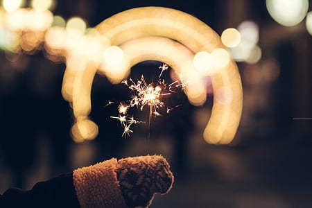 bokeh photography of person holding sparkler thumbnail