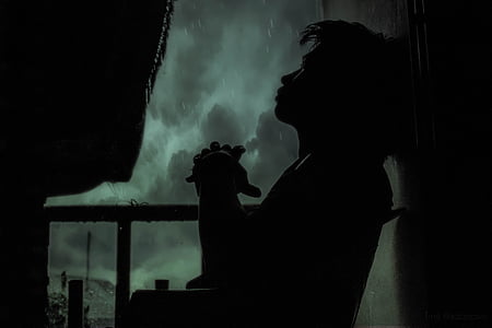 silhouette of man on chair leaning on wall thumbnail