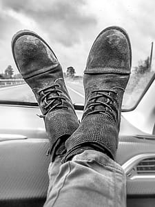 Grayscale Photography of Person's Feet on Vehicle Dashboard thumbnail