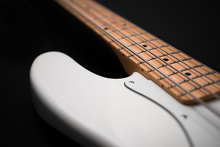 closeup photography of white and brown 4-string bass guitar thumbnail