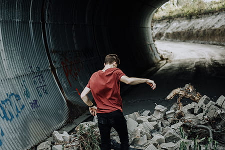 man walking on road near wall thumbnail