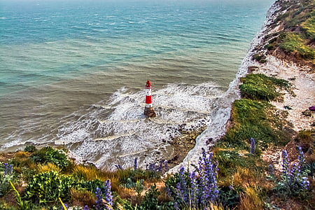 red and white lighthouse on body of water thumbnail