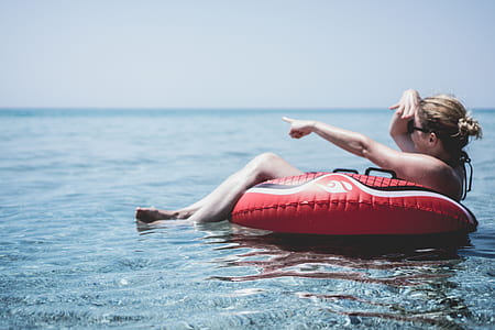 woman sunbathing on red pool float thumbnail