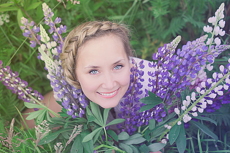 woman beside purple-and-white flowers thumbnail