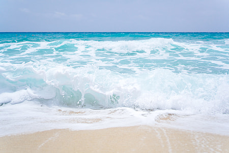 Blue ocean waves on a sandy beach thumbnail