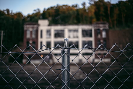 selective focus photography of gray metal chain-linked fence near building thumbnail
