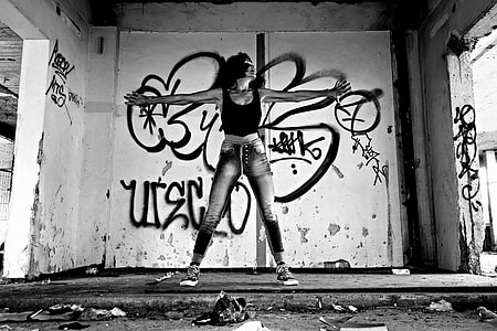 gray scale photo of woman in tank top and jeans thumbnail