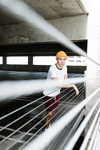 man leaning on railings inside building during daytime thumbnail