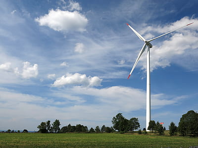 white wind turbine near house at daytime thumbnail