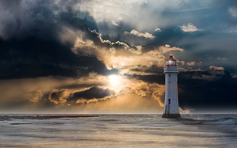 lighthouse near body of water during sunset thumbnail