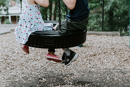 children riding on blue wheel swing thumbnail