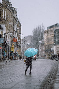 time lapse photography of woman standing on road under umbrella thumbnail
