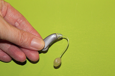 person holding gray hearing aid thumbnail