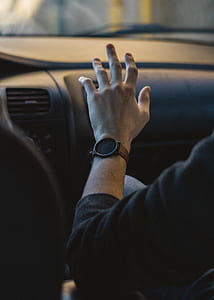 selective focus photography of person wearing round black analog watch thumbnail