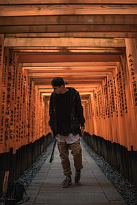 man walking between wooden arc thumbnail