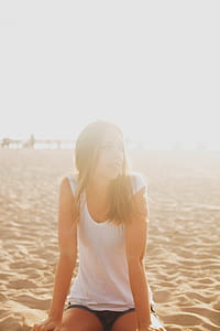 shallow focus photography of woman sitting on sand outdoor thumbnail