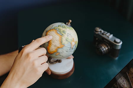 Male Finger Showing A Part Of The World On An Globe thumbnail