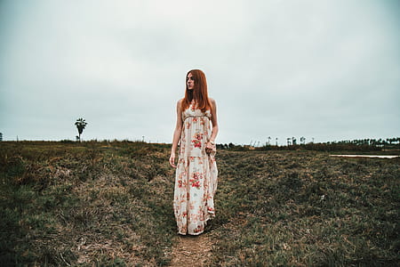 woman standing between grass during daytime thumbnail