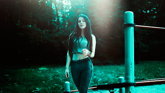 woman in gray sleeveless crop top and pants standing near post thumbnail