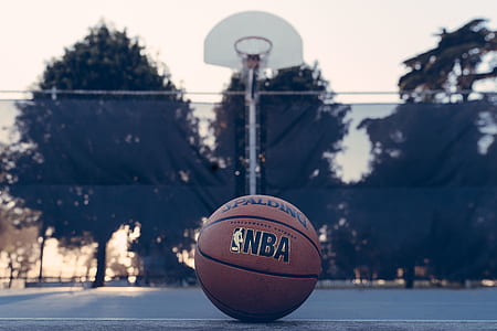brown NBA basketball near hoop during daytime thumbnail