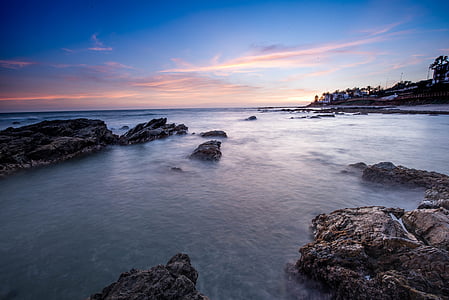 grey body of water under orange and blue sky thumbnail