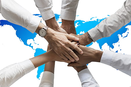 group of people rounding together with hands on center thumbnail