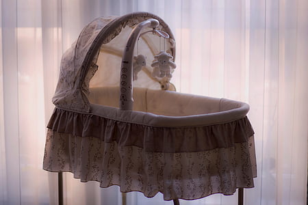 baby's white and gray bassinet beside white curtain thumbnail