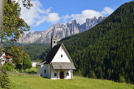 white and brown church near tall trees at daytime thumbnail