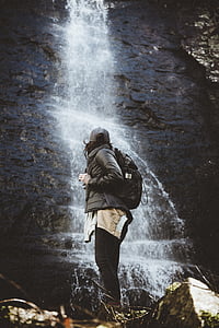 woman wearing black jacket facing waterfalls thumbnail
