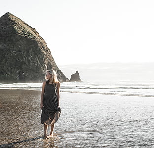 woman in gray dress standing on beach thumbnail
