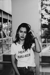 grayscale photography of woman holding her hair taking photo in front of wall post thumbnail