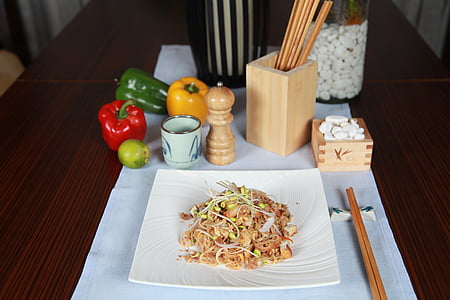 cooked food on white plate near pepper mill and chop sticks thumbnail