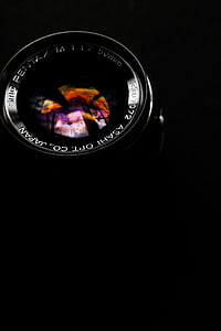 50mm black camera lens with black background closeup photo thumbnail
