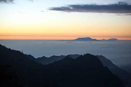 silhouette of mountain under cloudy sky thumbnail